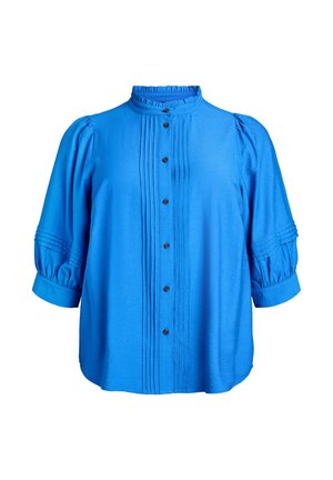 Zilas krāsas krekla krekls ar krokotu priekšpusi, augstu apkakli un uzpūstām piedurknēm ar aproču galiem. Izgatavots no gludas, vieglas auduma.