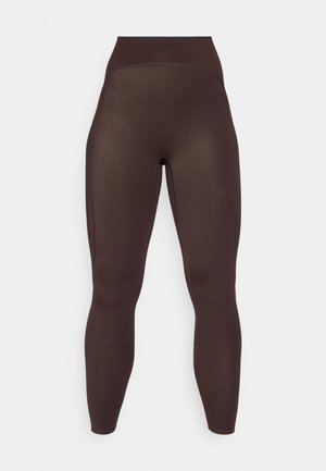 Mörkbruna högmidjade sömlösa leggings med en smal passform och slät textur, visade mot en enfärgad vit bakgrund.
