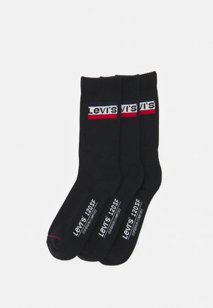 Três pares de meias de algodão pretas com um logotipo da Levi's em branco e vermelho na parte média, e informações de tamanho impressas nas solas.