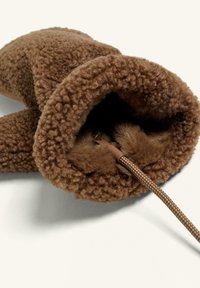 Hnědý papuče s fleecovou podšívkou, nadýchanou texturou, zaobleným tvarem a stahovacím šňůrkou pro úpravu, s měkkým kožíškovým vnitřkem.