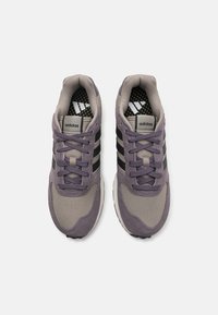 Ljubičasti i sivi Adidas tenisice imaju mre�žasti i antilop gornji dio, tri crne pruge i teksturiranu crno-žutu unutrašnjost.