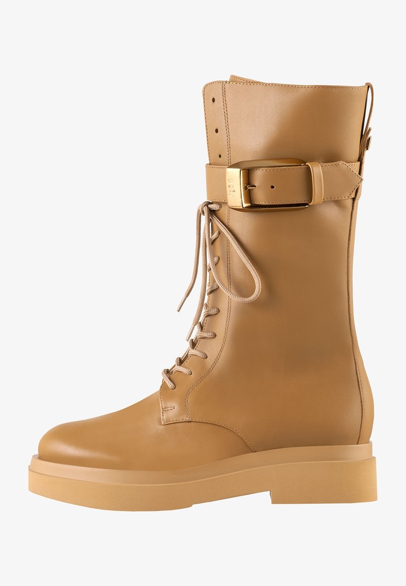 Tanleren veterschoenen met een brede band en een gouden gesp, een ronde neus en een robuuste zool voor stabiliteit.