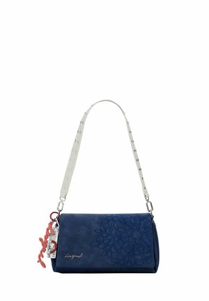 Marineblaue Handtasche mit floralem Relief, weißem genietetem Schulterriemen und rotem dekorativem Schlüsselanhänger an der Seite.