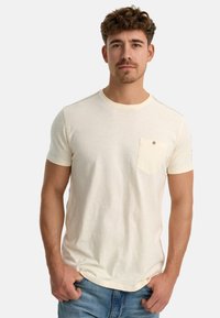 Cremefarbene Kurzarm-T-Shirts mit einer Tasche auf der linken Brust, runder Ausschnitt und dezenten Nahtakzenten.