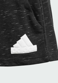 Tejido negro texturizado con el logo blanco de Adidas. El diseño incluye un patrón de ligeras variaciones de color.