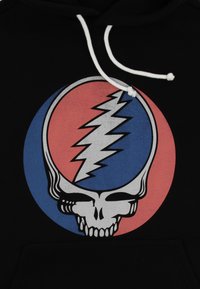 Felpa nera con cappuccio caratterizzata da una grande grafica di un teschio e un fulmine all'interno di cerchi rossi e blu. Cordini bianchi sul cappuccio.