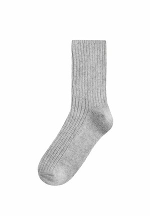 Pilka raištinė kojinė su vidutiniu storumu ir apvaliu pirštu. Tekstūra yra minkšta, su vertikalių raištelių raštais visame paviršiuje.