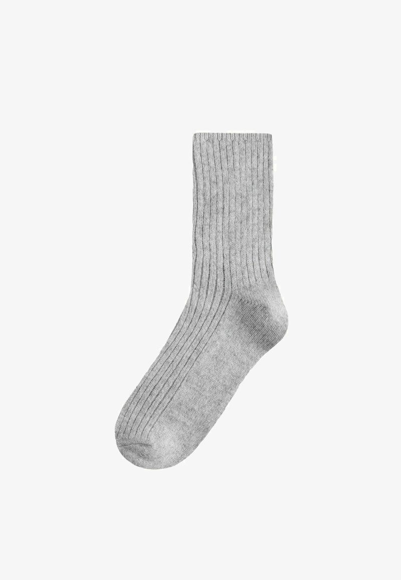 Calza grigia a coste con spessore medio e punta arrotondata. La texture è morbida, con motivi a coste verticali su tutta la superficie.