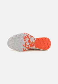 Sole di scarpa con una base bianca testurizzata e accenti arancioni. Presenta modelli di trazione angolari e un logo visibile sulla suola.
