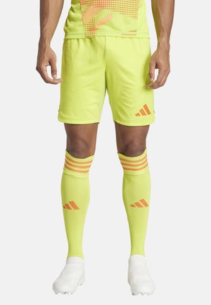 Leuchtend gelbe Fußballshorts und Socken mit orangen Akzenten. Die Shorts sind leicht, während die Socken horizontale Streifen und Logo-Details aufweisen.