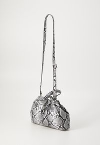 Borsa con motivo pitonato bianco e nero, dal design arricciato, con tracolla regolabile e superficie liscia. Presenta una forma compatta e dettagli in metallo.