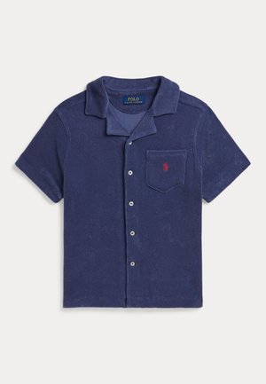 Tamsiai mėlyna trumpomis rankovėmis palaidinė su sagomis, stovyklos apykakle, krūtinės kišene ir mažu raudonu išsiuvinėtu Polo Ralph Lauren logotipu.