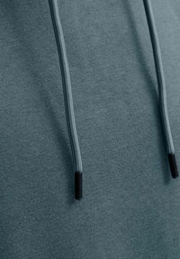 Kapuzenpullover aus tealfarbenem Stoff mit glatter Textur. Verfügt über Kordeln mit schwarzen Plastikschnüren. Einfaches, lässiges Design.