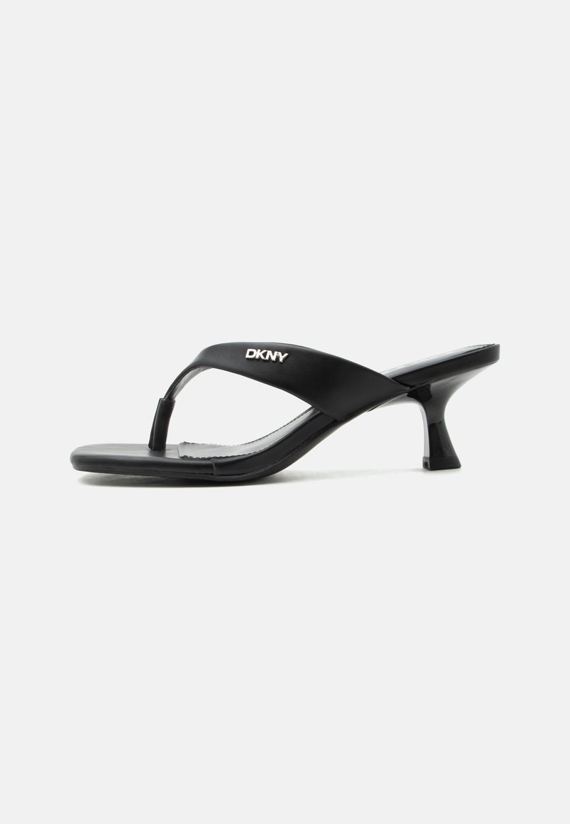 Μαύρο σανδάλι με τακούνι τύπου thong με λογότυπο DKNY στο λουράκι και λεπτό, καμπυλωτό μικρό τακούνι σε λευκό φόντο.
