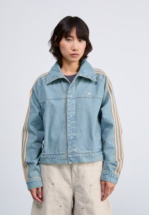 Denim jakna v svetlo modri barvi s ovratnikom, z rjavimi navpičnimi črtami na rokavih in majhnim logotipom na prsih. Teksturirana tkanina, sproščen fit.