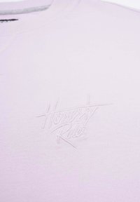 Ljus lavendelfärgad sweatshirt med en strukturerad, ton-i-ton broderad "Honesty Rules" logotyp. Mjuk tyg med ribbad halsringning.