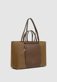 Braune Tragetasche mit glatter Textur, ausgestattet mit zwei Griffen und einer Fronttasche. Hergestellt aus robustem Material mit kontrastierenden Details.