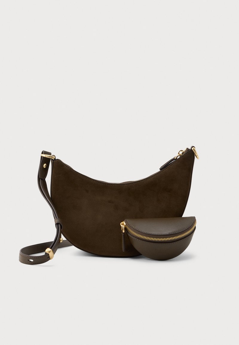 Bolsa de mão em camurça castanho-escuro em forma de meia-lua com alça ajustável e um pequeno porta-moedas de couro em forma de meia-lua a condizer, com fechos de correr dourados, sobre fundo branco.