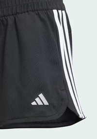 Pantalones cortos atléticos negros con diseño de tres rayas blancas, cinturilla elástica y un pequeño logo gris en el dobladillo, hechos de tela ligera.