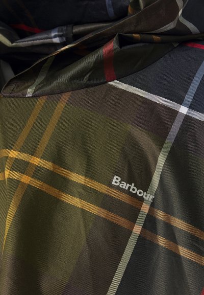 Платно с каре на Barbour в нюанси на зелено, кафяво и жълто, с шахматен мотив и бяло лого на текстурирана фон.