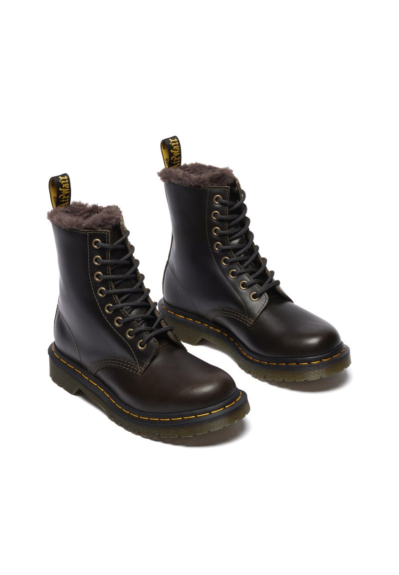 Zwarte leren enkellaarsjes met een bruin faux fur voering, vetersluiting, kenmerkende gele stiksels en een gestructureerde rubberen loopzool.