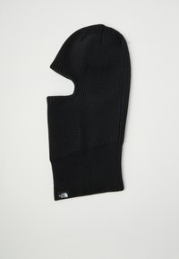 Melnā adīta balaclava ar noapaļotu augšu, kas nodrošina pilnīgu sejas segumu un ir ar atvērumiem acīm un mutei. Iespējots neliels logotipa tags.