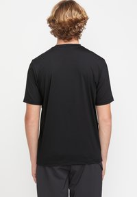 Czarny krótki rękaw T-shirt wykonany z gładkiego materiału. Prosty design z okrągłym dekoltem, bez widocznych wzorów ani akcentów.