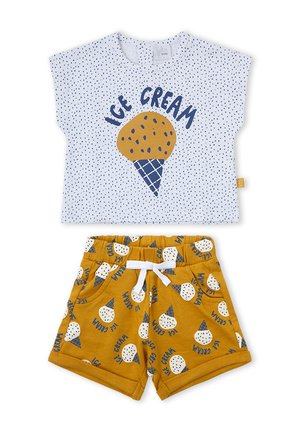 Camiseta blanca de manga corta con lunares azules y gráfico de cono de helado, combinada con pantalones cortos amarillo mostaza con patrón de cono de helado y cordón blanco.