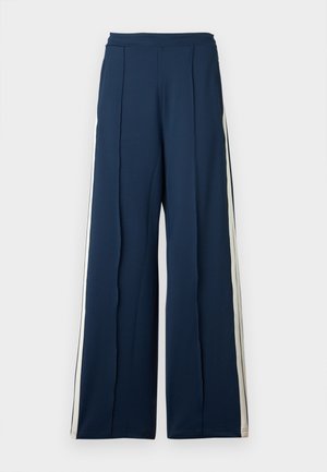 Weite Hose aus dunkelblauem Stoff mit seitlichen Streifen in Creme. Besitzt einen hohen Taillenbund und gefältelte Details für zusätzliche Struktur.