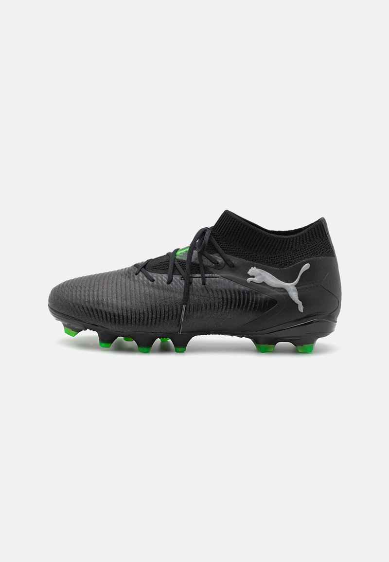 Black soccer cleats featuring a textured upper, high collar, green accent details, and a molded sole with green studs for traction.