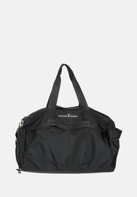 Fekete, tartós anyagból készült utazótáska, rövid fogantyúkkal, cipzáras felső résszel és egy elülső zsebbel, amelyen kontrasztos logó látható.