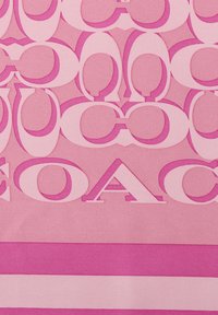 Lyserødt stof med store overlappende bogstaver i forskellige nuancer af pink. Teksturerne inkluderer glat og let skinnende, med horisontale farvebånd nederst.