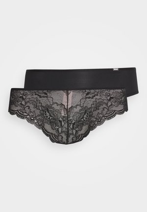 Schwarze Spitzenunterwäsche mit floralem Muster, gewellten Kanten und einem glatten Bund. Detailliertes Spitzenmuster bedeckt den Rücken.