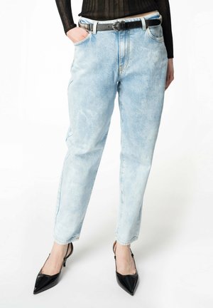 Jeans in denim azzurro chiaro con vestibilità rilassata, gamba dritta e tasche laterali. Abbinati a una cintura nera e tacchi neri a punta.