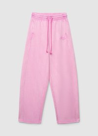Pantalon de survêtement rose en tissu doux, avec une taille élastique munie d'un cordon de serrage et une broderie de logo à l'avant. Coupe ample à jambes larges.