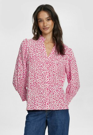 Blusa a fiori nei toni di rosa e bianco, con colletto a mocassino e maniche lunghe, realizzata in tessuto leggero e dalla vestibilità comoda.