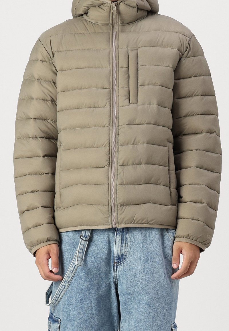 Prošívaná bunda v světle olivové barvě s vodorovným prošíváním, předním zipem a malou náprsní kapsou. Design s kapucí a měkkou texturou.