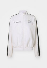 Weißer, verkürzter Blazer mit schwarzen seitlichen Streifen. Verfügt über einen hohen Kragen, elastische Bündchen und Saum sowie grafikartige Schriftzüge mit bunten Spritzern auf der Vorderseite.