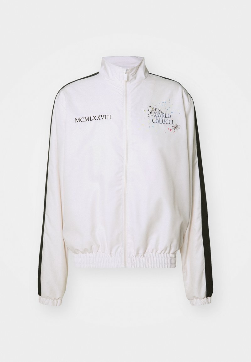 Weißer, verkürzter Blazer mit schwarzen seitlichen Streifen. Verfügt über einen hohen Kragen, elastische Bündchen und Saum sowie grafikartige Schriftzüge mit bunten Spritzern auf der Vorderseite.