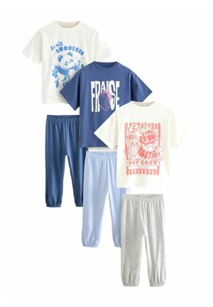 Zestaw odzieży dziecięcej składający się z czterech T-shirtów w różnych kolorach i wzorach, zestawionych z dopasowanymi spodniami z elastycznym pasem w kolorach niebieskim, szarym i jasnoniebieskim.