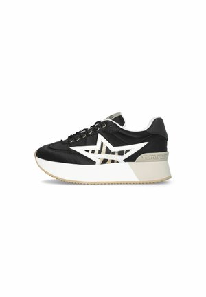 Sneaker bianco e nero con finitura lucida, design a stella prominente, suola piattaforma spessa e accenti beige a contrasto.