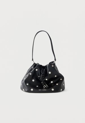 Sac à main en cuir noir avec le haut froncé, clous argentés, cordon noué et bandoulière simple sur fond blanc.