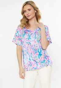 Kortärmad, v-ringad topp i pastellfärger. Har ett blommönster med rosa, blå och gröna nyanser. Tillverkad av ett lätt material.