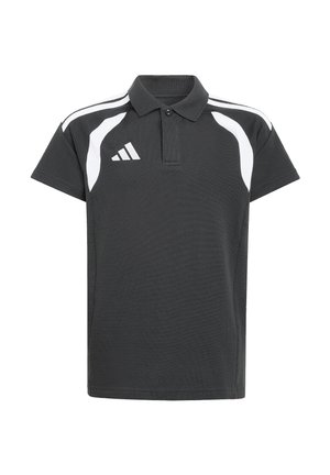Junge steht und trägt ein schwarz-weißes sportliches Poloshirt sowie passende schwarze Sporthosen mit weißen Streifen.