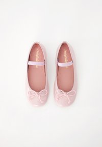 Ballerines roses pâles avec une finition brillante, bout rond, bande élastique douce et un accent de nœud à l'avant. Semelle intérieure légèrement rembourrée.