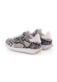 Sneaker mit einem schwarz-weißen Schlangenledermuster, ausgestattet mit einem strukturierten Obermaterial, weißen Schnürsenkeln und einer hellen Gummisohle mit Profilnoppen.