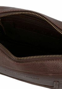 Funda de cuero marrón con cremallera de latón abierta que muestra un interior oscuro con un bolsillo interior con cremallera.