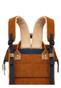 Zaino in corduroy marrone con spallacci imbottiti beige e dettagli blu navy. Presenta rifiniture in pelle e hardware metallico. Chiusure a fibbia regolabili.