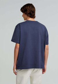 Mørkeblå, kortærmet t-shirt med rund halsudskæring. Lavet af et blødt materiale, med en afslappet pasform og ensartet design, uden synlige mønstre.