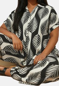 Set di camicia e pantaloni con motivo a foglie in bianco e nero, realizzato in tessuto testurizzato, con colletto e maniche corte, dotato di bottoni.